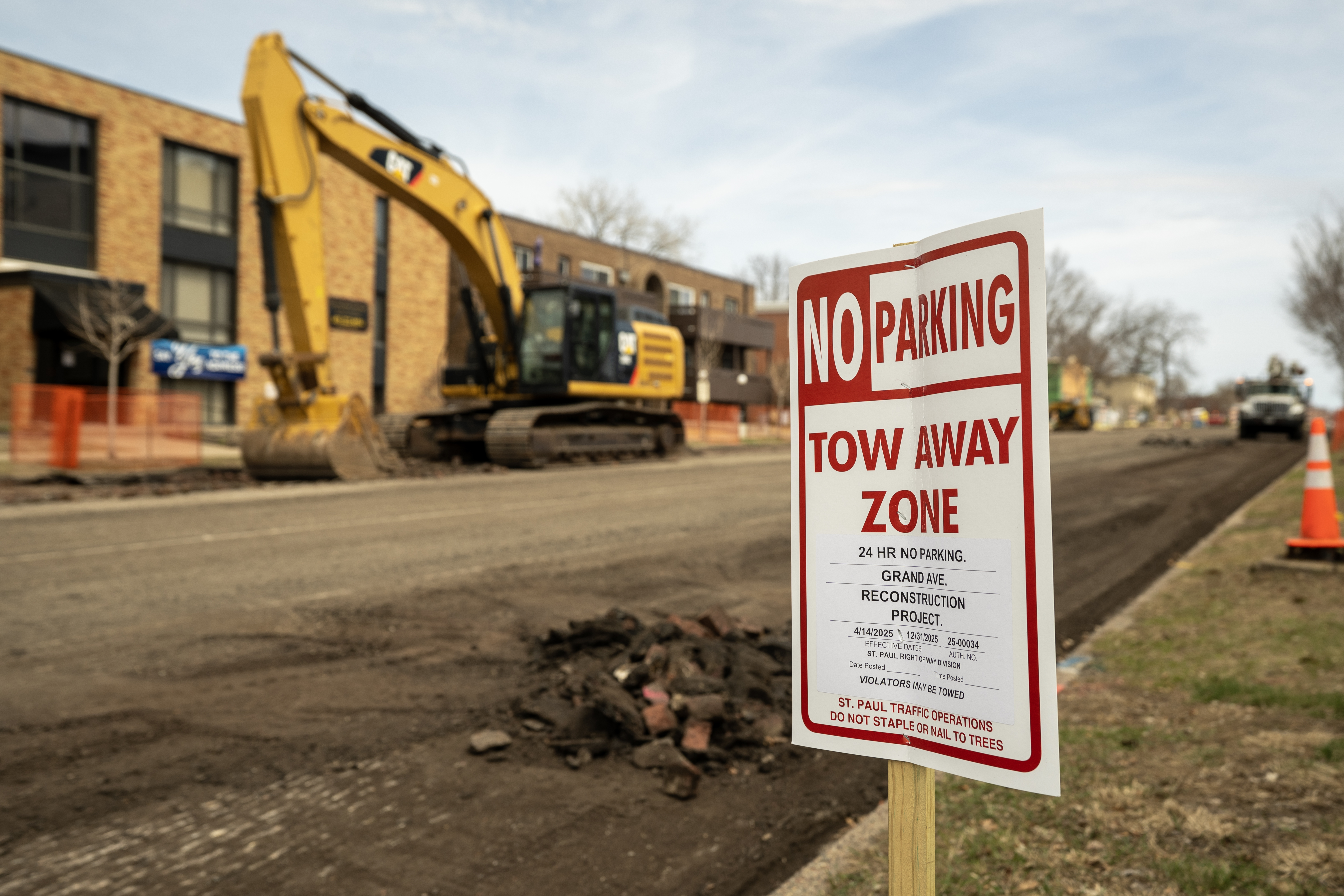Temporary "No Parking" placed along a curb. Street construction in the background.