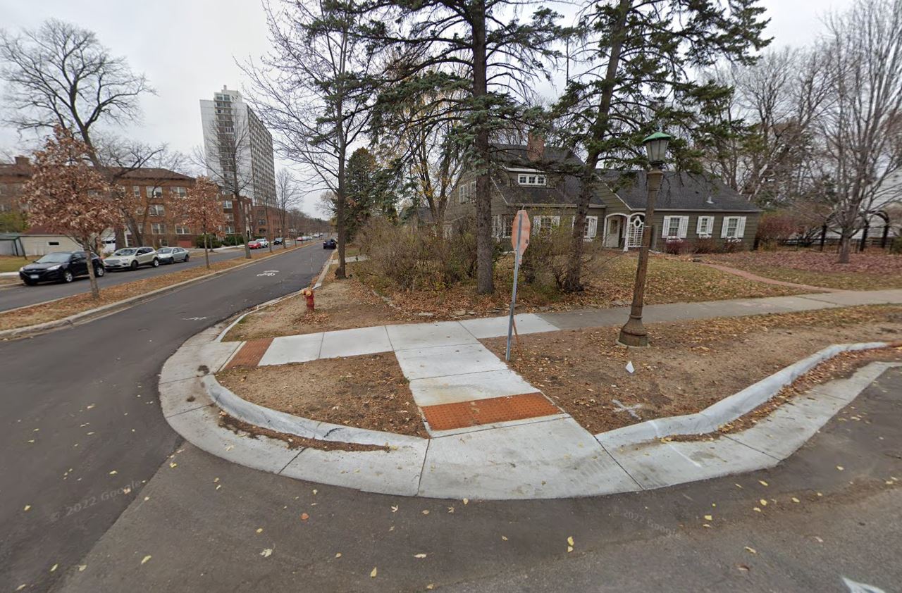 Street intersection with a concrete bumpout at the corner to shorten the pedestrian crossing distance