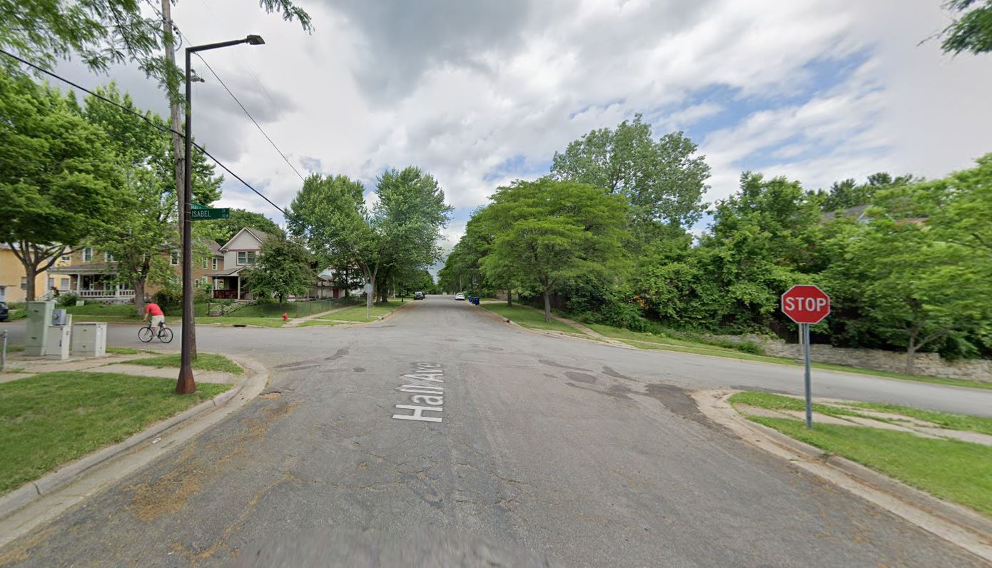 Street intersection with stop sign positioned behind the sidewalk crossing.