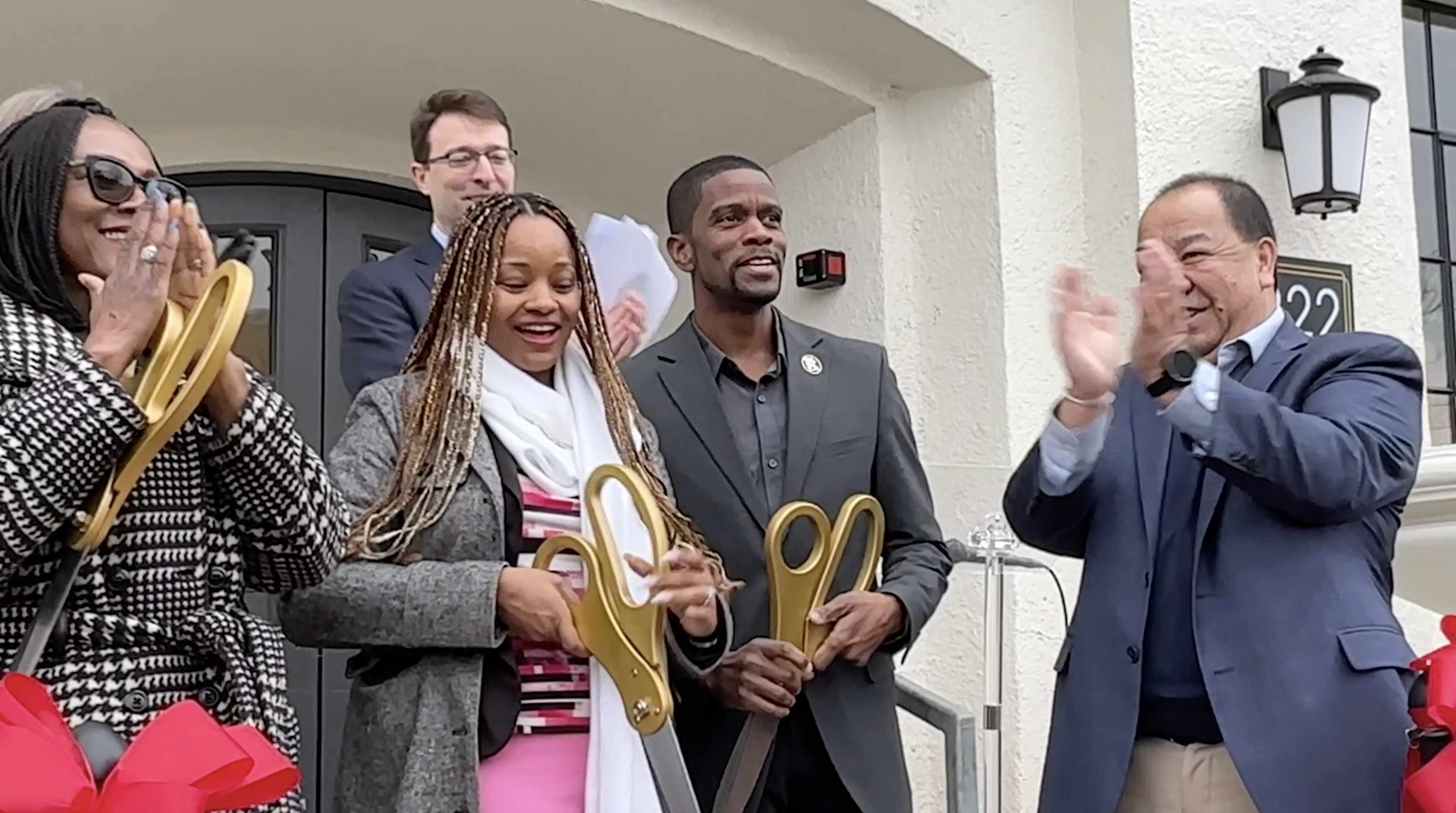 Councilmember Anika Bowie, Mayor Melvin Carter, developers and community members cut a ribbon at the Twelve 22 Apartments on University Avenue.