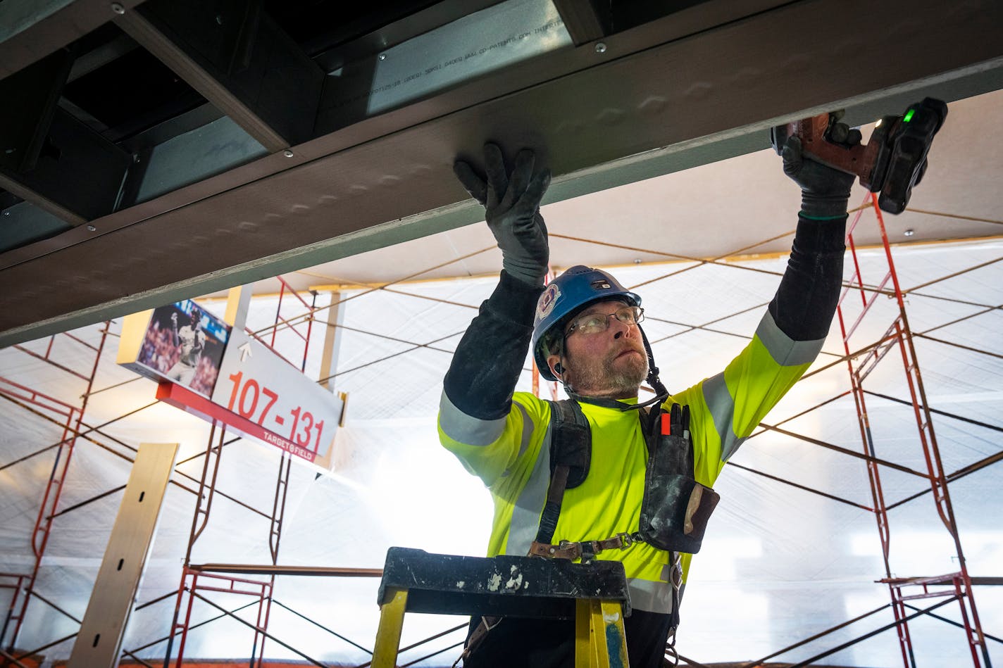 A construction worker does maintenance work on a stadium