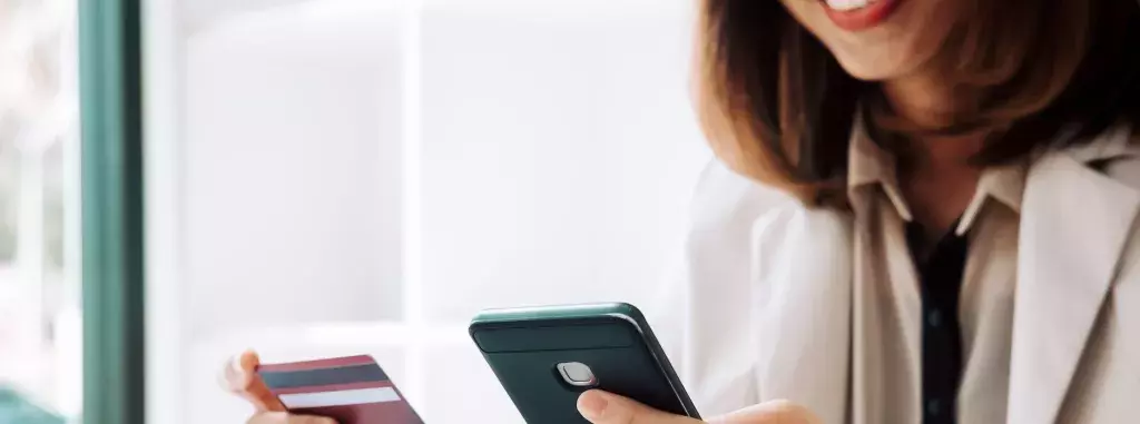 Woman holding a mobile phone and credit card