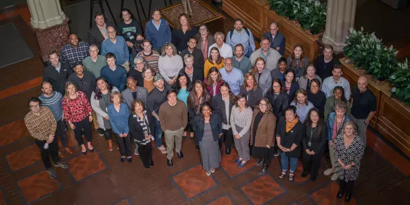 Aerial view of department staff, approximately 50 people, in the atrium of Landmark Center.