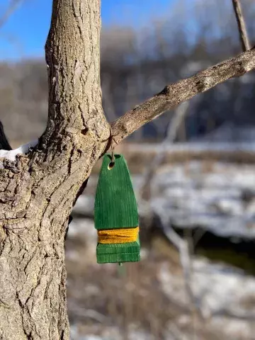 Wooden Evergreen Tree statue hanging on a tree in a park