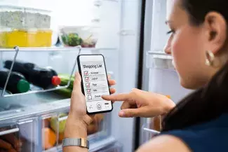 Woman Shopping Fridge and making a list