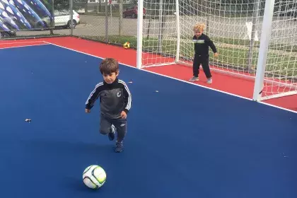 Youth playing futsal on Hamline Park futsal court